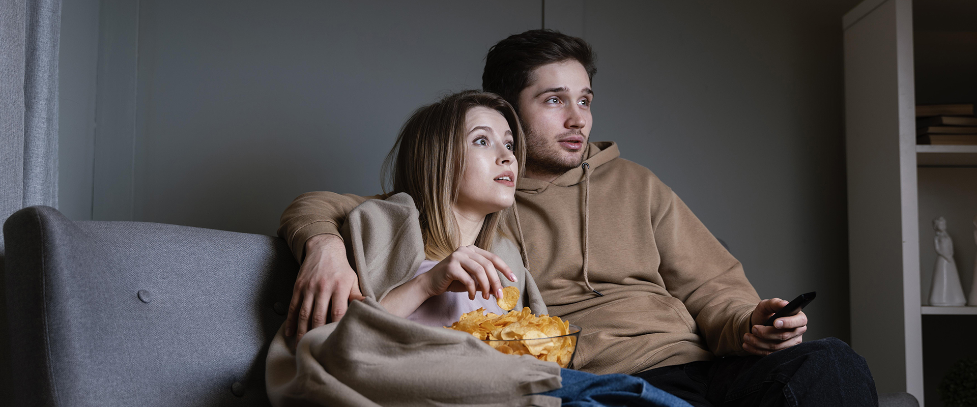 pareja-sofa-viendo-television-comiendo-patatas-fritas